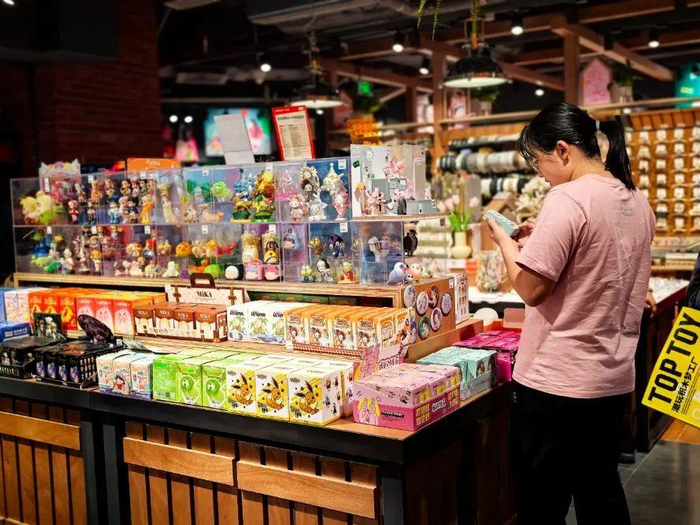 图为消费者在北京王府井apm购物中心生活方式集合店番茄口袋选购盲盒。（中国商报记者 涂瀚文/摄）