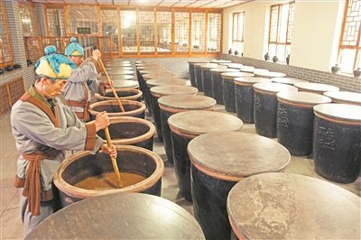 ②    图②：山西省清徐县宝源老醋坊的工人师傅在搅拌原料加速酒精发酵。山西省清徐县融媒体中心供图