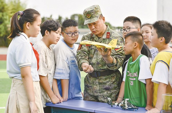 9月6日，在安徽省合肥市古城小学，该市庐阳区民兵用武器装备模型向学生介绍装备性能。图片来源：视觉中国