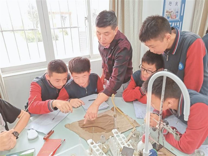     蒲毅（左三）指导学生做实验。 （开阳县第五中学供图）