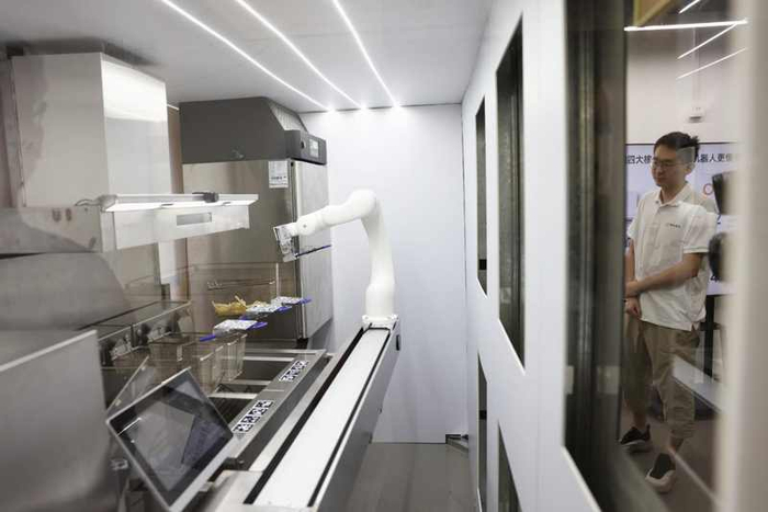 餐饮行业首个具身智能机器人LAVA现场炸薯条。新京报记者 浦峰 摄