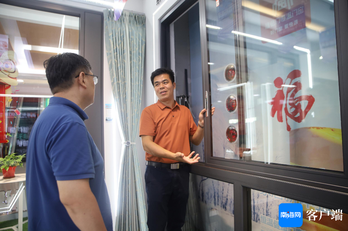 朱守杰在给记者讲解玻璃窗知识。记者 王威 摄