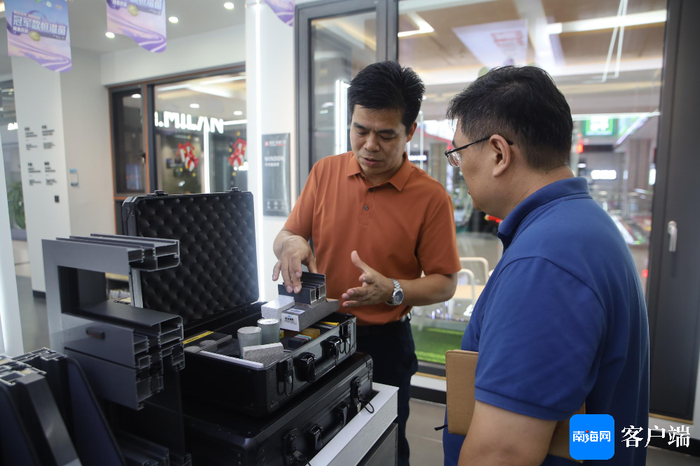 朱守杰在给记者讲解玻璃窗知识。记者 王威 摄