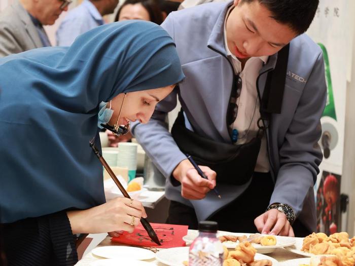 1月29日，沙特阿拉伯利雅得苏尔坦亲王大学学生在孔子学院展位体验中国书法。新华社记者王海洲摄