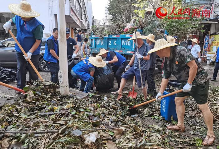 9月12日，海口市综合行政执法局的志愿者在海达社区附近清理道路。人民网记者 毛雷摄