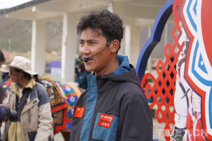 图为平措益西介绍岗莎村牦牛运输队情况 摄影：张宇