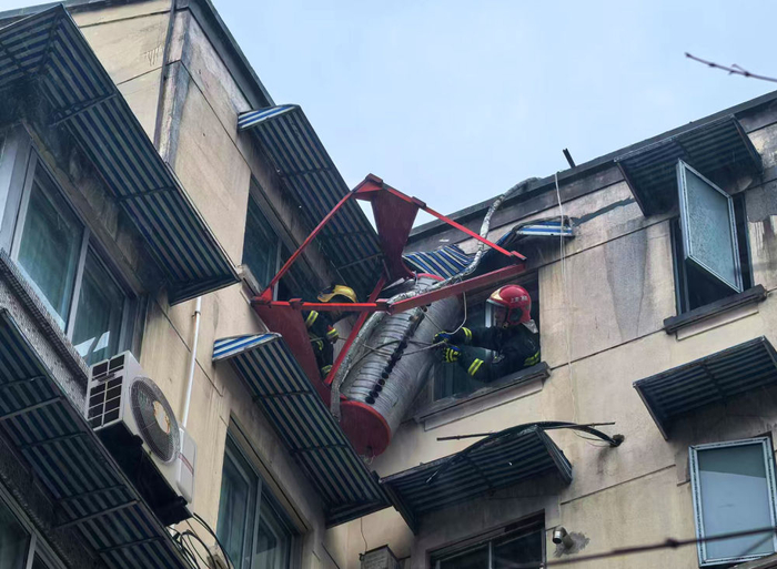   9月16日，上海普陀消防救援支队消防员用绳索将脱落的楼顶热水器吊装到地面。新华社记者方喆摄