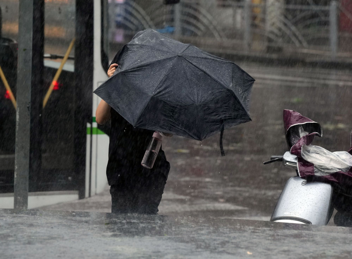   9月16日，在上海闵行区，行人在风雨中前行。新华社记者刘颖摄