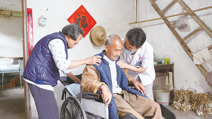 舒城县中医院阙店乡分院医生姚洋上门为居民换药。