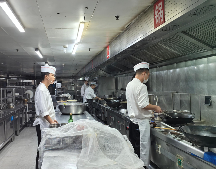 西安饭庄大唐不夜城店后厨工作人员的操作情况。徐文智/摄