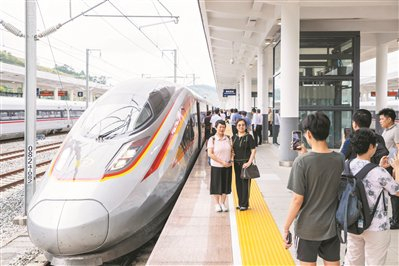 梅龙高铁首趟车抵达梅州西站后，乘客在车头留影。