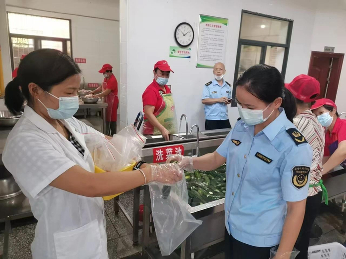执法人员到学校食堂抽取食材样品进行快检。长汀县市场监管局供图