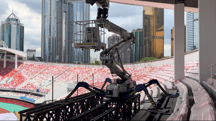 （高空蜘蛛车正在天河体育中心进行钢结构雨篷除锈翻新）