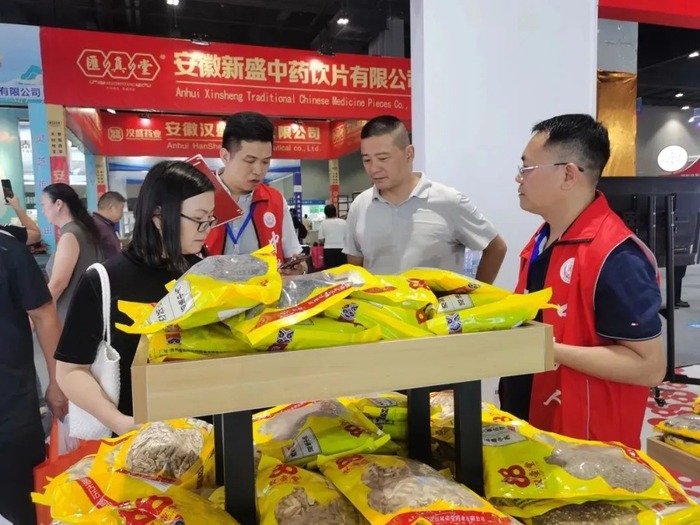 贵州馆里参展商向客户介绍产品。