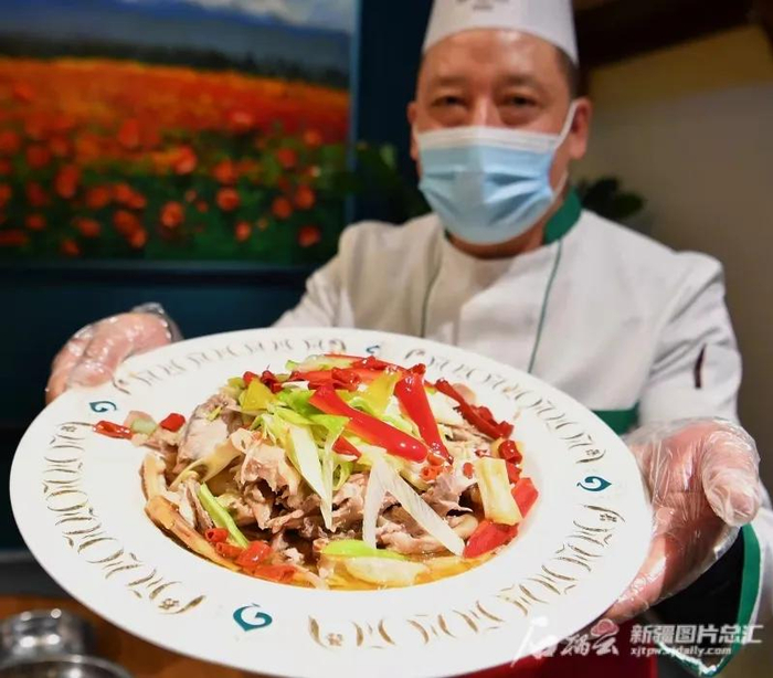 新疆某餐厅员工在展示特色椒麻鸡（资料图片）。石榴云/新疆日报记者 邹懿摄