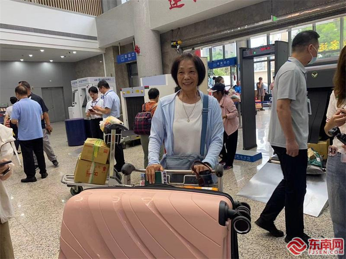 台胞谢素瑾推着行李安检候船。