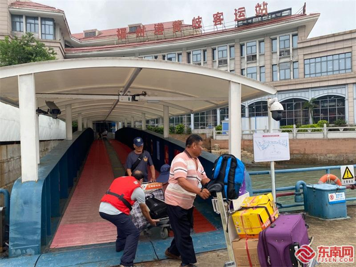 现场工作人员帮旅客搬行李。