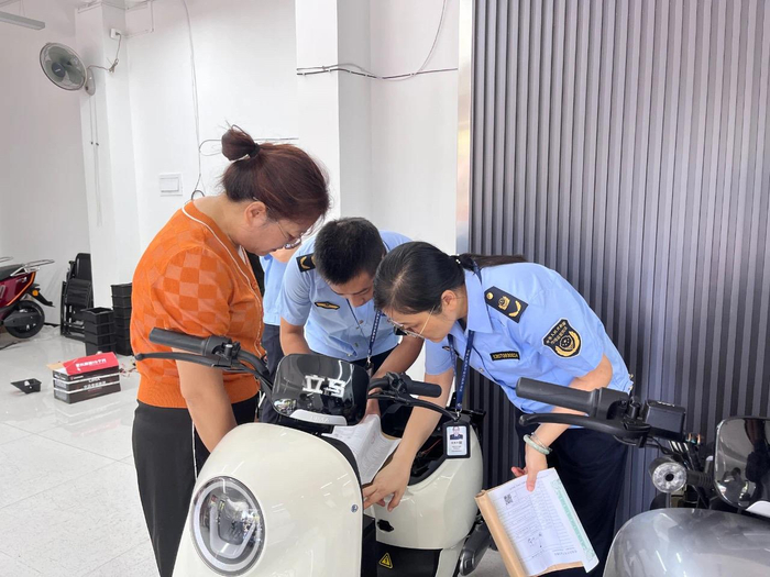 执法人员现场核查电动自行车的产品标识、合格证等情况。