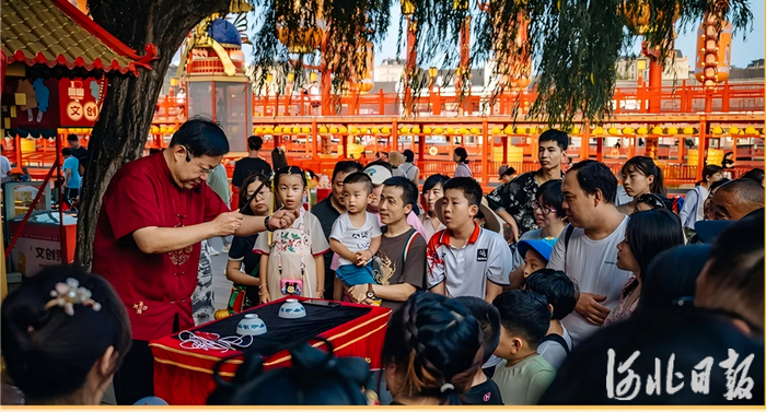 中秋假期，河头老街景区内，游客正在观看戏法表演。 河头老街景区供图
