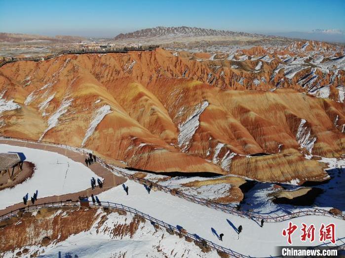 图为游客在雪后的张掖七彩丹霞旅游景区游览。(资料图) 杨艳敏 摄