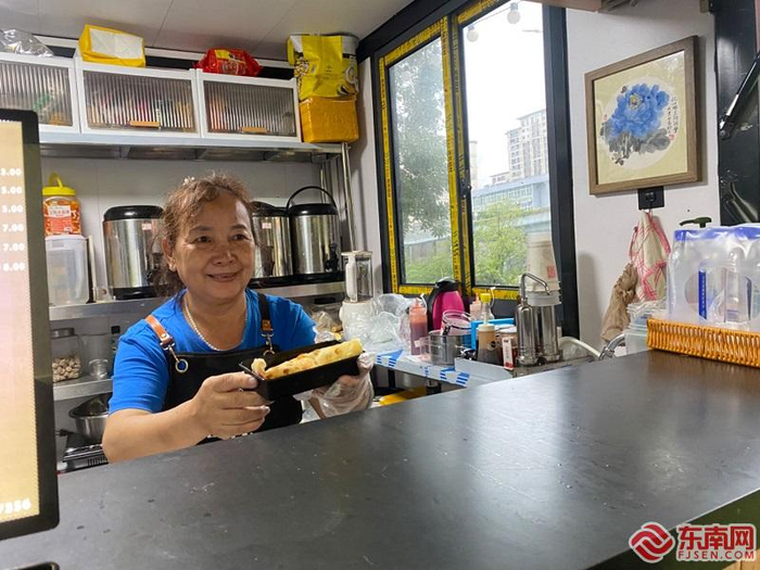 王淑娟端出食品给顾客。