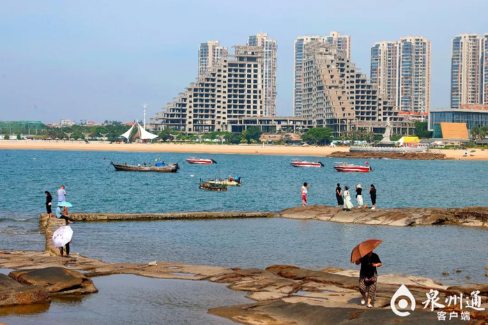 在石狮洛伽寺边的黄金海岸，游客们吹着海风感受蔚蓝海岸的魅力。（资料图片 陈晓东 /摄）