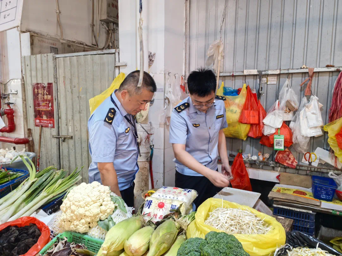 执法人员对农贸市场电子秤进行检查。
