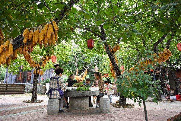 9月21日，山东滕州，龙泉山脚下的一家农家乐店外，服务员正在为中午营业做准备。 图片来源：视觉中国