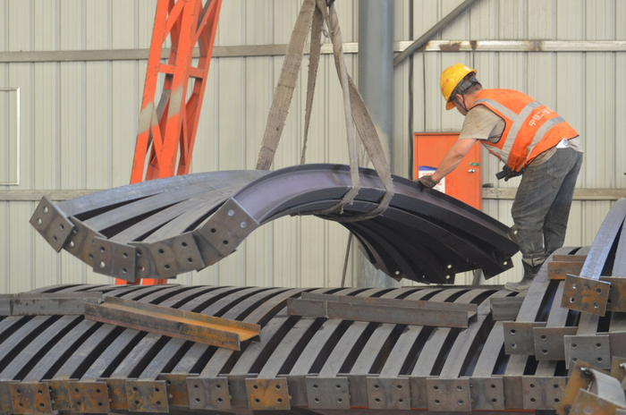 图为中铁二十局工人在兰永临高速公路建设现场搬运建材（许岗摄）