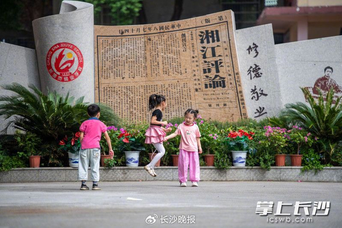 修业学校内，孩子们在湘江评论雕塑前玩耍。长沙晚报全媒体记者 郭雨滴 摄