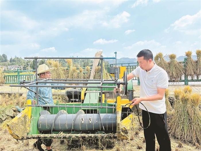 游永彬（右）帮助村民检修收割机。（受访者供图）