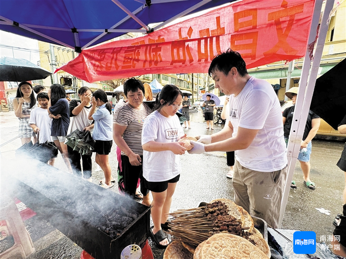 三名新疆小伙为文昌锦山民众送羊肉串、烤馕。记者 郑光平 摄
