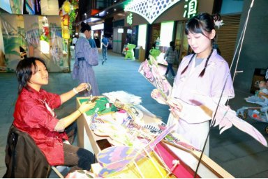 图为9月23日，游客在水云间文化商街非遗市集挑选非遗产品。