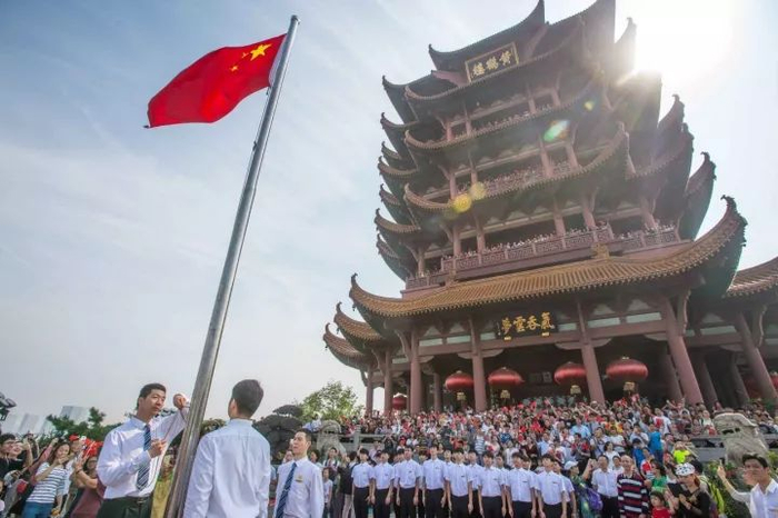 △2017年国庆，来自五湖四海的游客在黄鹤楼前挥舞国旗，共同庆祝祖国生日。
