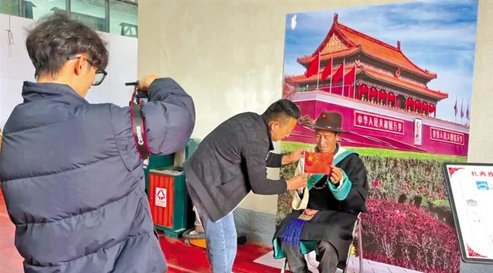         图为史振鑫为群众拍摄照片。本报记者 索朗群培 本报见习记者 旦增措姆 摄    
