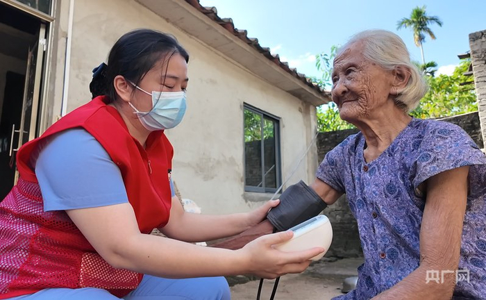 “小屯妹”志愿者庞秀菱为郑阿婆量血压（央广网记者  付美斌  摄）