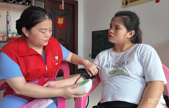 “小屯妹”志愿者庞秀菱为孕妇量血压（央广网记者  付美斌  摄）