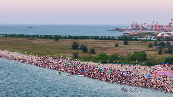 日落时分，紫霞湾海滩人头攒动。郑恩茵 摄
