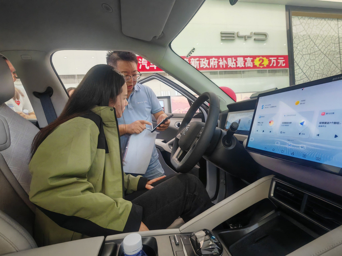 顾客正在听销售人员介绍车辆信息。新华社记者 苏醒 摄