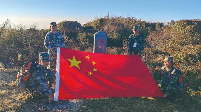 蔡新装（左二）与界务员们在“共和国1号碑”旁合影。来源：中国民族报