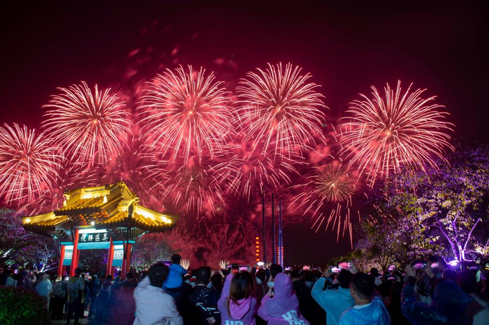  10月5日晚，在江苏无锡太湖鼋头渚举办的水上音乐烟花大会上，游客在观赏烟花表演。新华社发（潘正光摄）