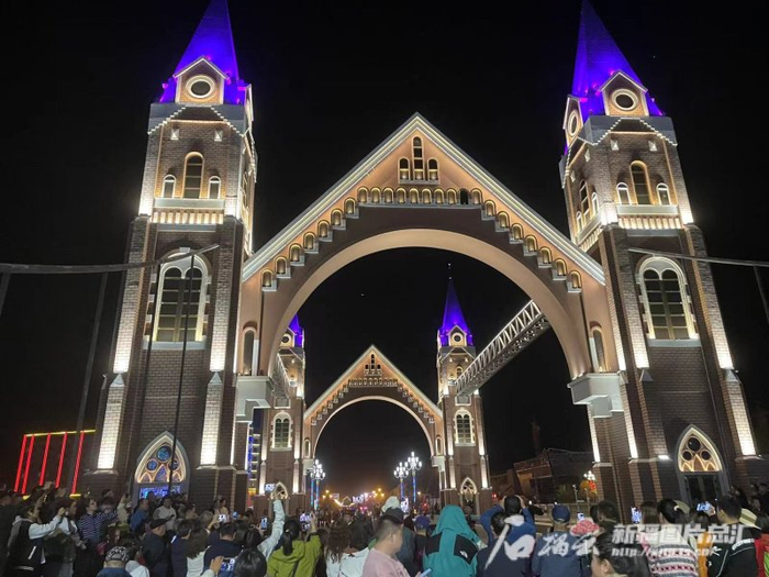 　　布尔津县喀纳斯塔桥上文艺演出吸引游人拍照。石榴云/新疆日报记者姚刚摄