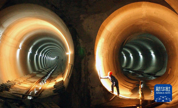 2003年12月10日，南京地铁一号线一期工程实现全线贯通，一名工人在南京站隧道内调整照明灯光。