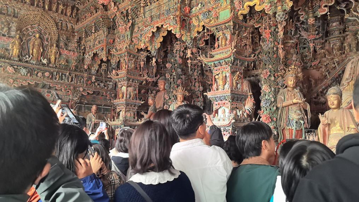 游客在隰县小西天景区欣赏满堂悬塑。（受访者供图）