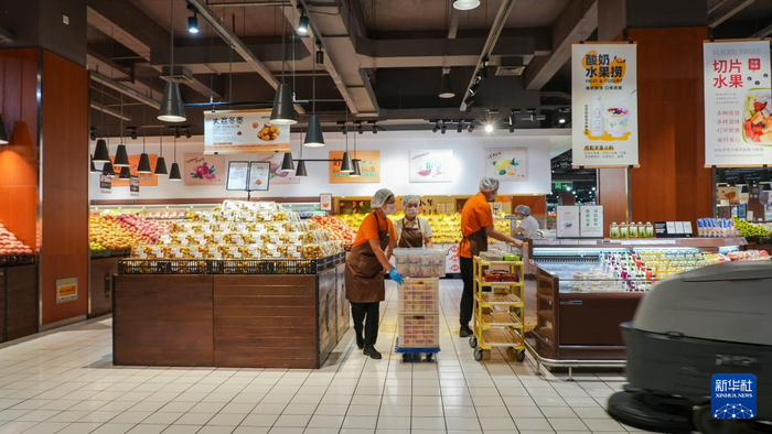 2024年8月22日，在许昌胖东来时代广场店，店员在做开业前的准备工作。新华社记者 刘振坤 摄