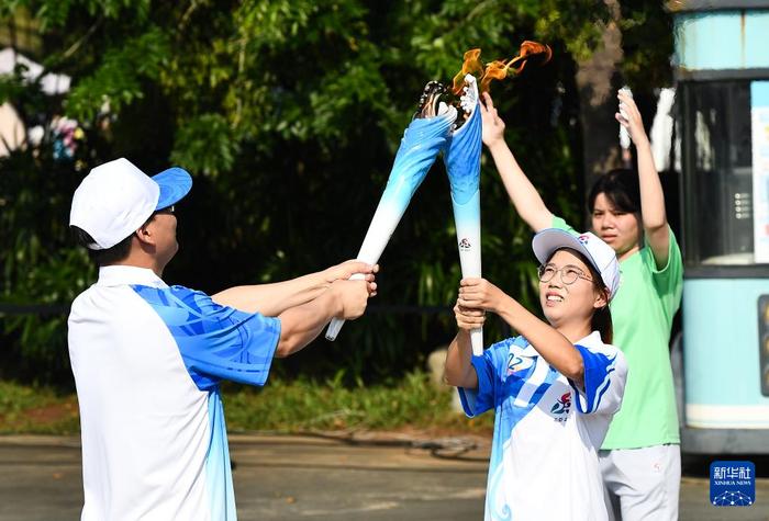   10月9日，第一棒火炬手徐洪周（左）与第二棒火炬手邓火红进行火炬传递。新华社记者 杨冠宇 摄