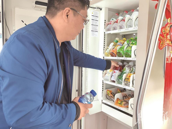 公交集团工作人员为自动售货机补货。