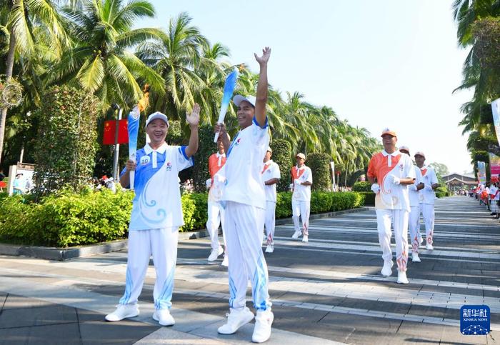   10月9日，第十棒火炬手梁永朝（左）与第十一棒火炬手陈秀兴进行火炬传递。新华社记者 杨冠宇 摄