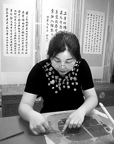 谢俭华在修复字画文物。资料图片