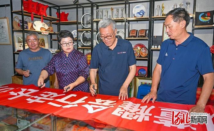 7月26日，董耀会（右二）在榆林长城主题展馆与当地长城保护志愿者交流。 河北日报记者赵杰 摄